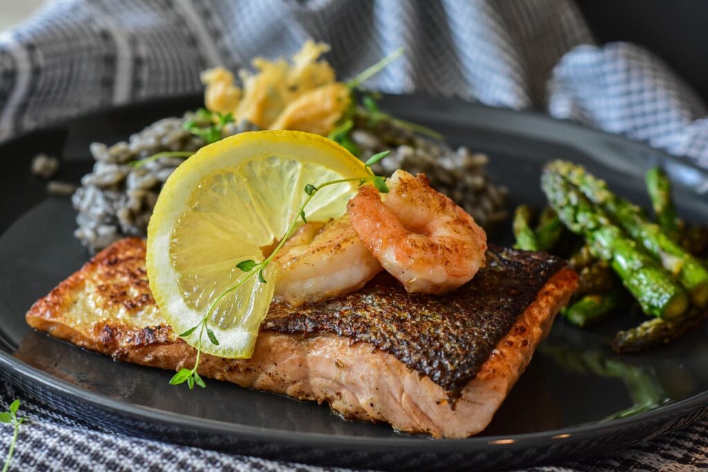 a plate of Grilled Salmon with a lemon slice and rice